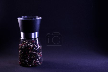 Photo for Fragrant multicolor goroko pepper in a pepper shaker on a black background - Royalty Free Image