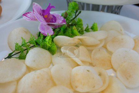 Kerupuk, una especie de snack hecho de harina de arroz, servido en un pequeño plato aislado sobre un fondo blanco. Alta calidad