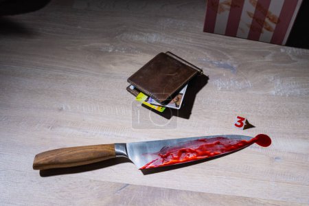 en la escena del crimen, un cuchillo en la sangre y una billetera con documentos