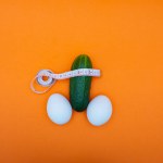 Cucumber and eggs on an orange background. The concept of healthy food, diet and potency.
