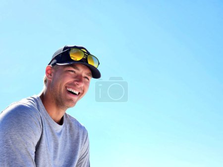 Glücklicher Millennial-Typ am Strand lächelt im Urlaub vor Rührung. 
