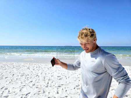 Happy millennial man leaving beach after cellphone call on vacation. 
