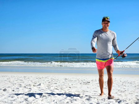 Glücklicher Millennial verlässt das Meer in rosa Badeanzug in Florida. 