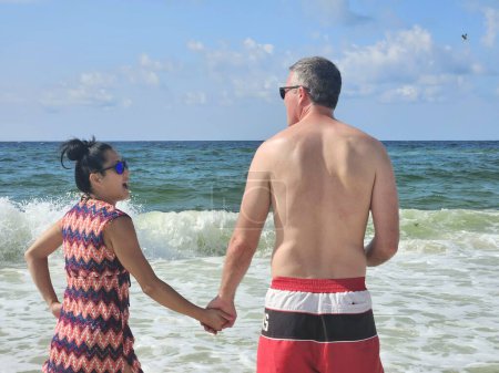 Casado diversificada generación X pareja por detrás tener conversación en la playa en verano en vacaciones. 