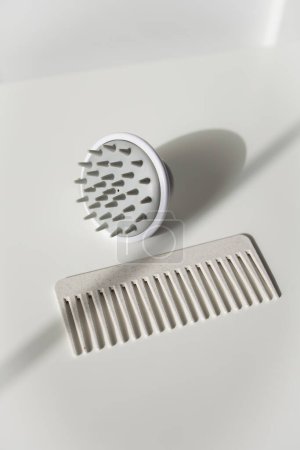 Grey hair comb and scalp massager on white background