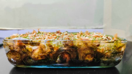 A homemade Japanese food Takoyaki in a square glass tray on a black and white background
