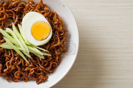 Téléchargez les photos : Nouille instantanée coréenne à la sauce aux haricots noirs garnie de concombre et d'œuf bouilli (Jajangmyeon ou JJajangmyeon) - style alimentaire coréen - en image libre de droit