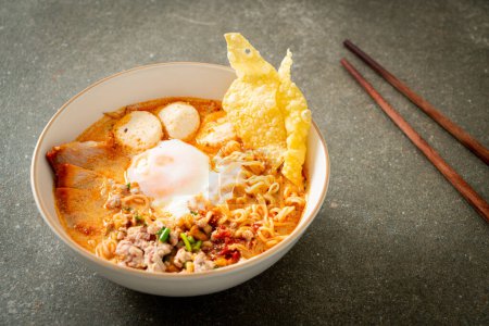 Téléchargez les photos : Nouilles instantanées au porc et boulettes de viande dans une soupe épicée ou nouilles Tom Yum dans un style asiatique - en image libre de droit