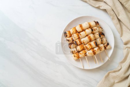 Foto de Pastel de pasta de pescado en forma de tubo a la parrilla o pincho de calamar tubo en placa - Imagen libre de derechos
