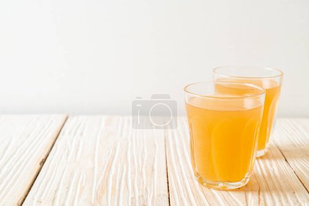 Téléchargez les photos : Verre de jus de gingembre frais et chaud avec des racines de gingembre style boisson saine - en image libre de droit