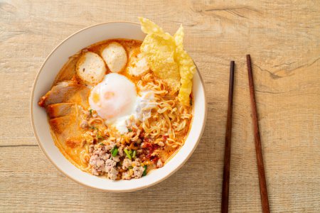 Téléchargez les photos : Nouilles instantanées au porc et boulettes de viande dans une soupe épicée ou nouilles Tom Yum dans un style asiatique - en image libre de droit