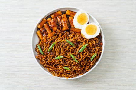 Photo for Jjajang Rabokki - Korean instant noodles or Ramyeon with Korean rice cake or Tteokbokki and egg in black bean sauce - Korean food style - Royalty Free Image