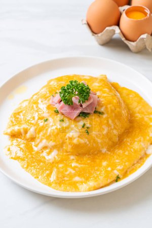 Cremiges Omelett mit Schinken auf Reis oder Reis mit Schinken und weichem Omelett