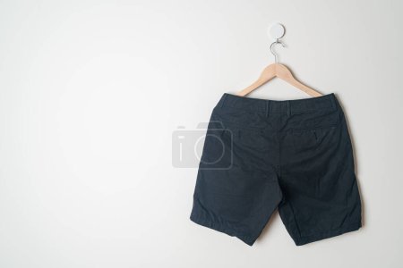 short pants hanging with wood hanger on wall