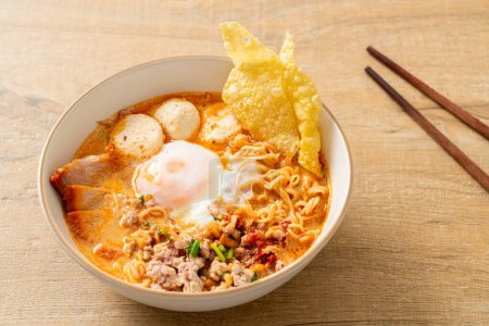 Instant-Nudeln mit Schweinefleisch und Frikadellen in würziger Suppe oder Tom Yum Noodles im asiatischen Stil