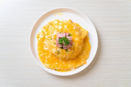 Cremiges Omelett mit Schinken auf Reis oder Reis mit Schinken und weichem Omelett
