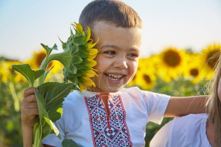 Happy girl in Ukrainian clothes - embroiderers in a field of sunflowers