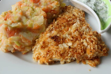 Backfisch mit Kartoffelpüree und Gemüsepüree auf einem Teller