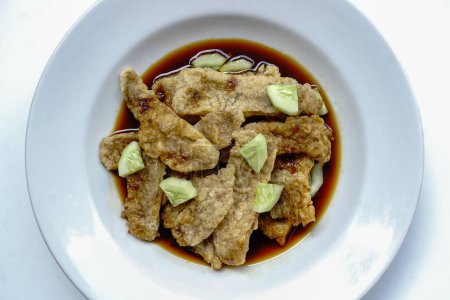 Pempek Kulit, comida tradicional del sur de Sumatra, Indonesia. Este alimento a base de pescado es muy popular. Servido con salsa de cuko y rodajas de pepino en plato blanco.                               