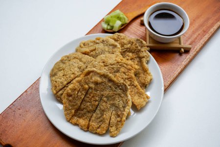 Photo for Pempek Kulit, traditional food from South Sumatra, Indonesia. This fish-based food is very popular. Served with cuko sauce and cucumber slices. - Royalty Free Image