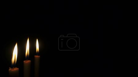 Téléchargez les photos : Bougies brûlantes sur fond noir - en image libre de droit