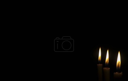 Téléchargez les photos : Lumière de bougie sur fond noir - en image libre de droit