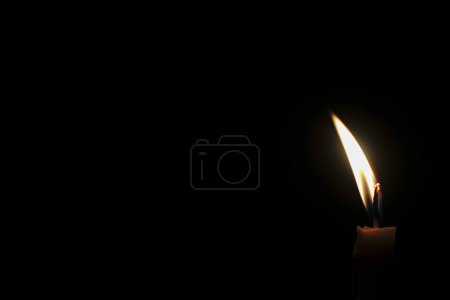 Téléchargez les photos : Bougie allumée isolée sur fond sombre - en image libre de droit
