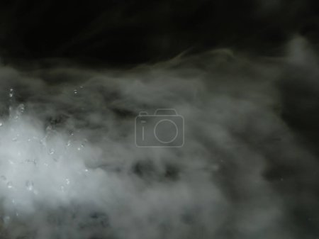 De vraies micro gouttes d'eau chaude sont pulvérisées dans l'air. des nuages d'un jet épais tourbillonnent. brouillard de fumée sèche. état gazeux. 
