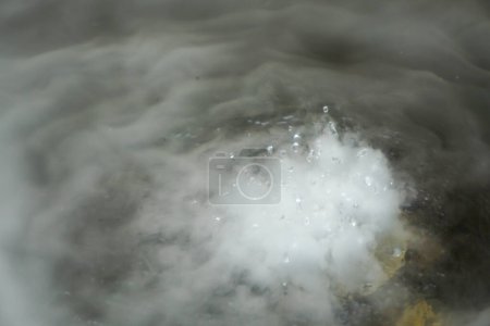 Echte Mikrotropfen heißen Wassers werden in die Luft gesprüht. Wolken eines dicken Jets wirbeln auf. trockener Rauchnebel. gasförmiger Zustand. 