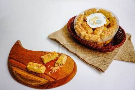 Hausgemachte, knusprige Kaastengel-Kekse, holländischer Einfluss indonesische Kekse, dienten zur Feier von Idul Fitri oder Eid Fitri. Selektives Fokusbild auf weißem Hintergrund. Textübersetzung ist Eid Mubarak
