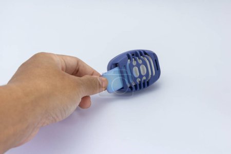 Person inserting electric anti-mosquito repellent in the blue socket for mosquitoes protection at home. Electric vaporizer fumigator insect repellenton a white background. Isolate. dengue protection