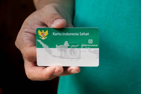 Hand haltend indonesische staatliche Krankenversicherungskarte oder (Kartu BPJS Kesehatan oder Kartu Indonesia Sehat)
