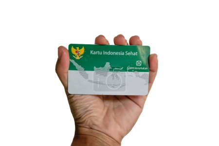 Hand hält indonesische staatliche Krankenversicherungskarte oder (Kartu BPJS Kesehatan oder Kartu Indonesia Sehat) isoliert auf weißem Hintergrund, Jakarta - Indonesien, 16. Mai 2023