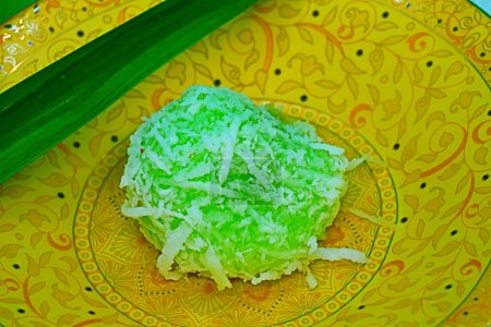 Entdecken Sie die Essenz der malaysischen Küche mit unserem legendären Dessert: ein hausgemachtes Vergnügen aus klebrigem Reisteig, Kokosnuss und rotem Palmzucker, perfekt zubereitet und mit Kokosfetzen serviert.