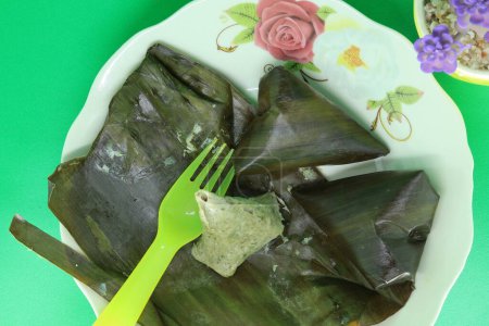 Legendary Malaysian recipe known as "Sata" featuring fish flesh, coconut shreds, and chili. Homemade and wrapped in banana leaves, this delicious cake is steamed and served at hawker stalls for meals or breakfast.