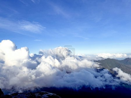 Téléchargez les photos : Nuages épais recouvrant la montagne, brouillard blanc sur la montagne, nuages apparaissant le matin - en image libre de droit