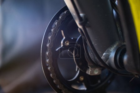 Cinematic close-up view of the main chainring of a bicycle, showing the links of the bicycle chain, slightly dirty.