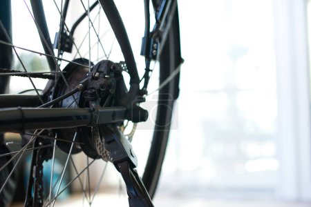 Nahaufnahme des Hinterrades eines E-Bikes mit Bremsscheibe und Ständer. Heller Hintergrund rechts passend für Text.