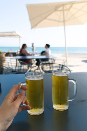 Foto de Durres, Albania - 13 de abril de 2024 - foto de dos vasos llenos de cerveza fría en un bar de playa cerca del paseo marítimo. - Imagen libre de derechos