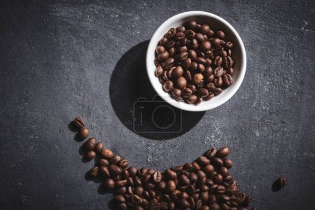Téléchargez les photos : Coupe blanche de grains de café torréfiés fraîchement brassés sur fond gris - en image libre de droit