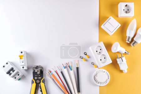 Téléchargez les photos : Outils électriques réglés avec variateur isolé sur fond blanc jaune avec espace de copie, éclairage contrôlable. Concept d'économie d'énergie, construction et rénovation - en image libre de droit