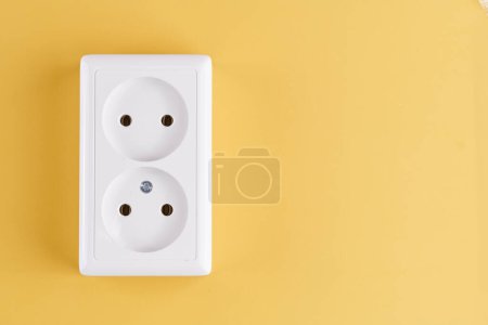 Photo for White double socket isolated on yellow background. Electric lighting concept - Royalty Free Image