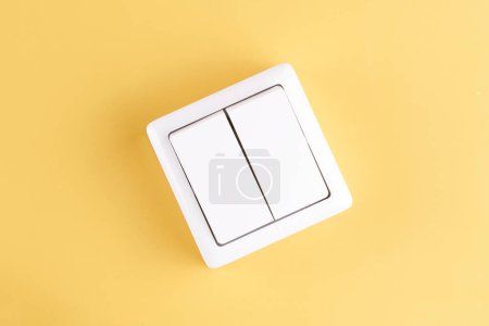 Photo for White double light switch isolated on yellow background. On/Off - Royalty Free Image