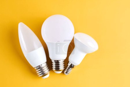 Foto de Diferentes tipos de bombillas aisladas sobre fondo amarillo - Imagen libre de derechos
