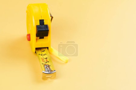 Photo for Yellow carpenter measuring tape with centimeters isolated on yellow background. Construction tool. - Royalty Free Image