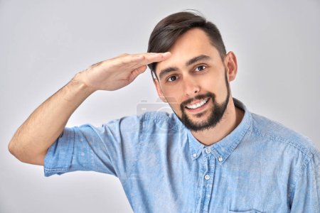 Photo for Caucasian young male in casual looks future, looking far away distance with hand over head isolated on white background. Search concept. - Royalty Free Image