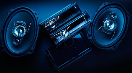 Foto de Altavoces de sonido de coche negro y grabadora de cinta de radio de primer plano sobre fondo negro, sistema de audio, subwoofer de graves duros, panel de control - Imagen libre de derechos