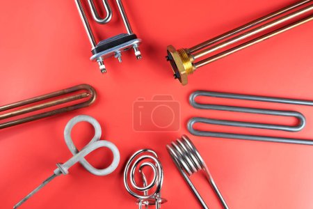 Photo for Set of different types Tubular electric Heating elements made of steel for washing machines, boiling water, heating, isolated on red background - Royalty Free Image