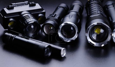 Foto de Set de linternas tácticas de bolsillo negro aisladas sobre fondo negro - Imagen libre de derechos