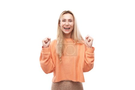 Foto de Retrato positivo chica rubia emocionalmente se regocija y se siente feliz satisfecho aislado sobre fondo blanco, banner de publicidad - Imagen libre de derechos